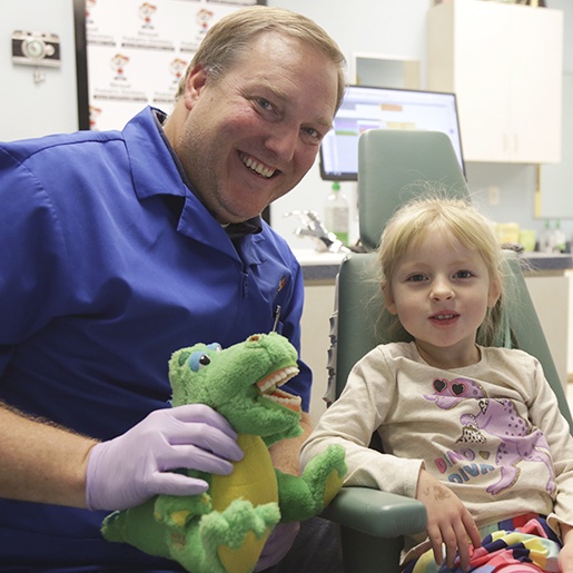Dentist and smiling child in dental exam room