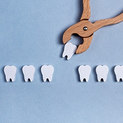 Wooden teeth and dental pliers extracting one