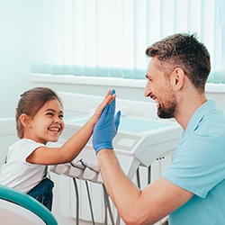a child high-fiving a dentist after undergoing nitrous oxide sedation