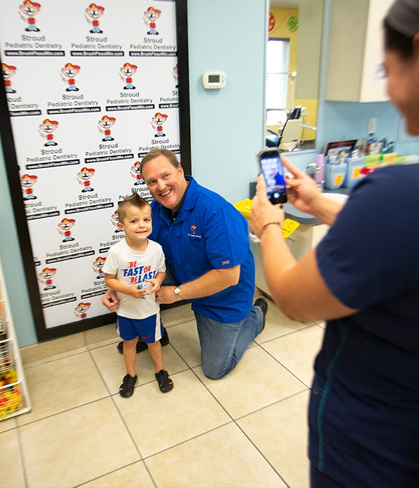 Dentist and young patient taking picture together