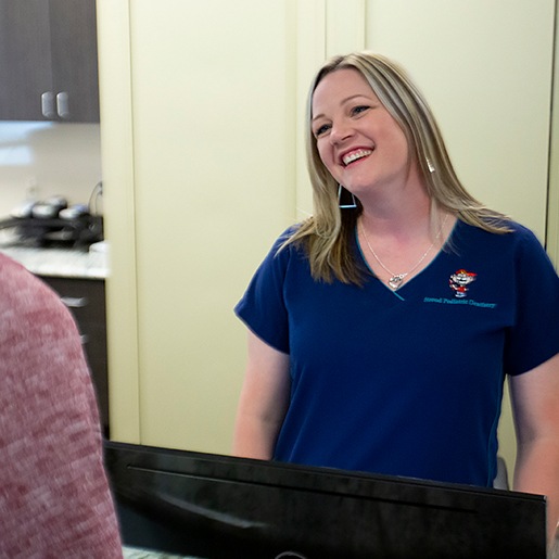 Team member smiling behind reception desk