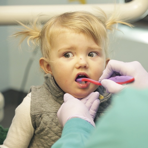 Team member brushing child's teeth