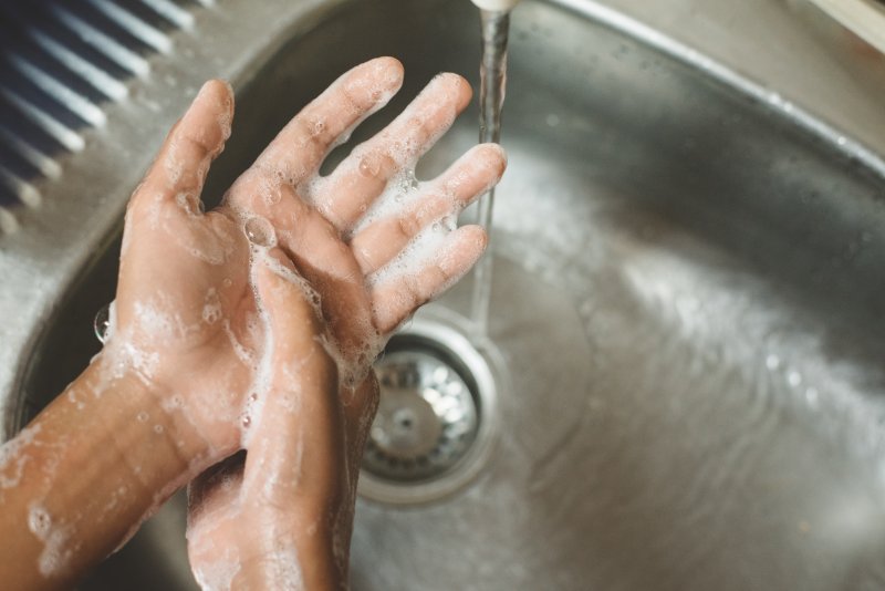 a person washing their hands with soap and water