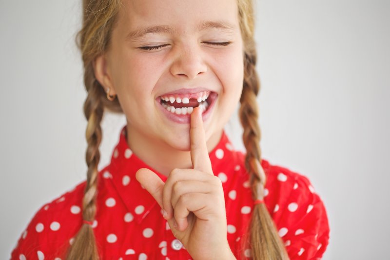 Child smiling with missing tooth