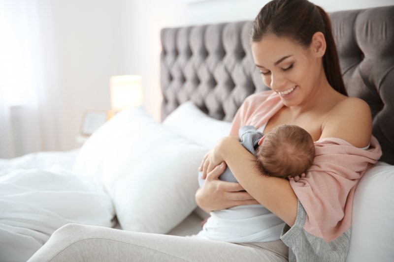 Mom smiling at breastfeeding baby
