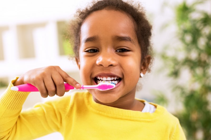 young girl brushing teeth 