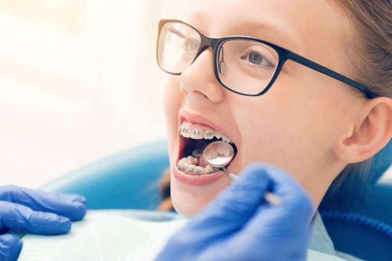 A dentist checking a child's baby teeth for cavities