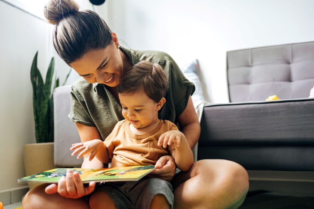Woman reading picture book to child sitting in her lap