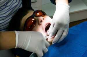 Child being worked on by dentist. 
